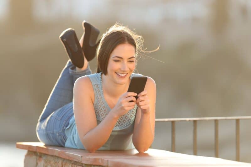Young woman enjoying reading quality content on her smartphone
